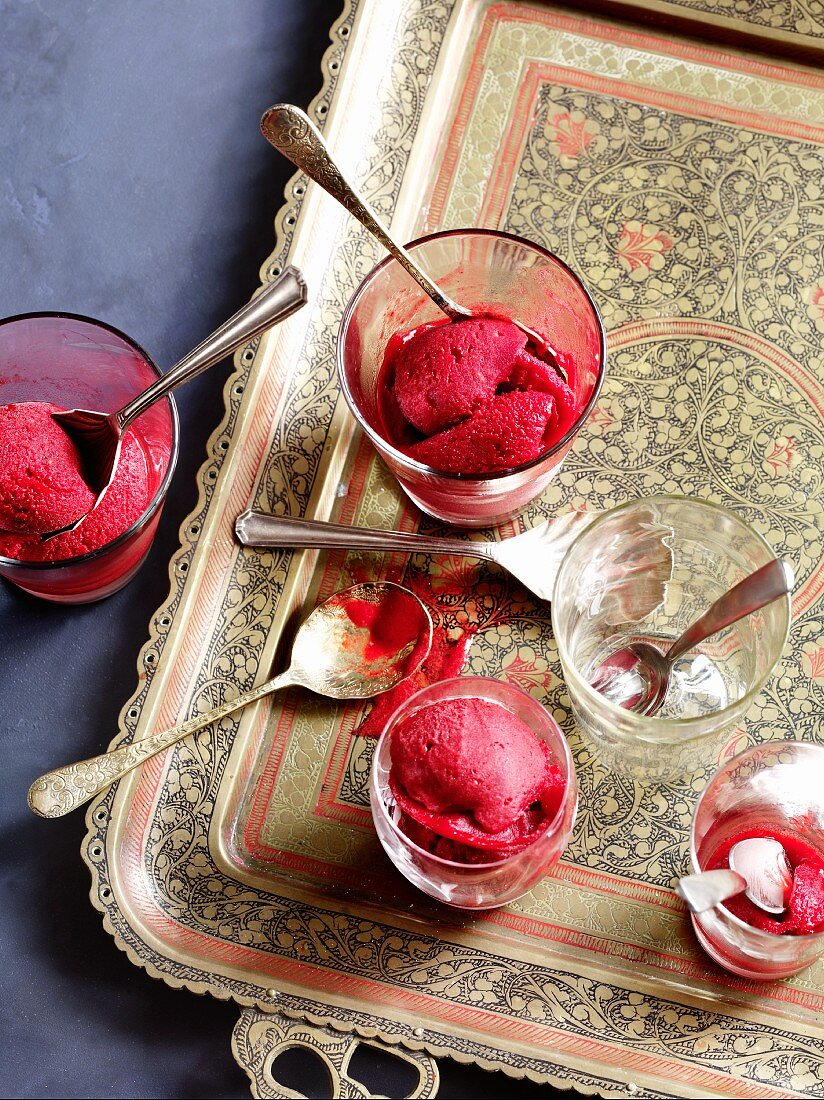 Raspberry sorbet in dessert glasses on a tray
