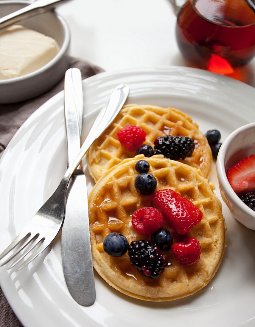 Waffles with butter, maple syrup and berries