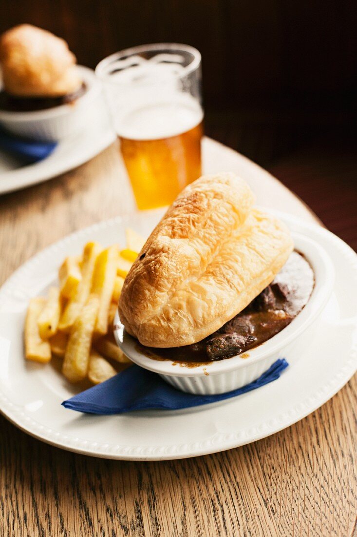 Steak and ale pie served with chips and a glass of ale