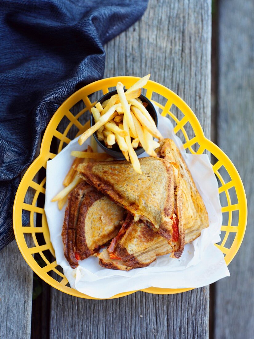 Toasted ham and cheese sandwiches with fried in a plastic basket