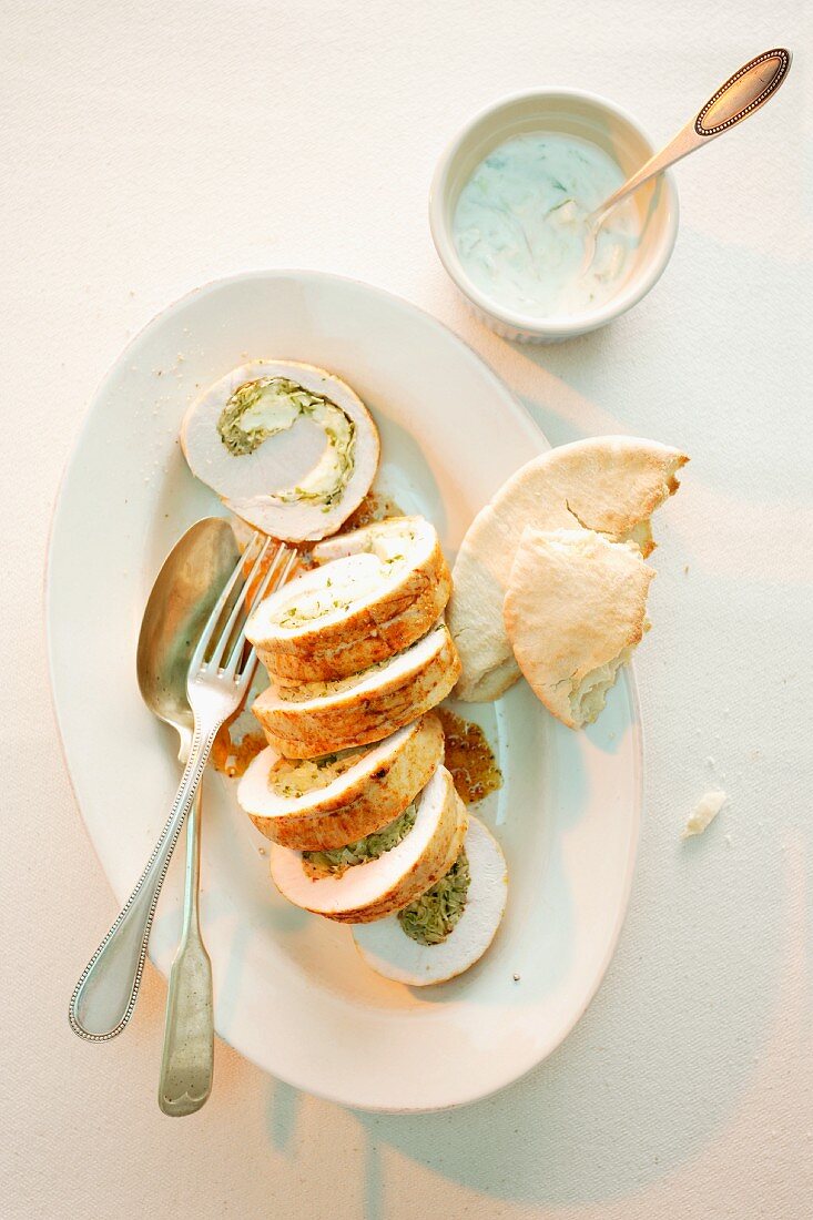 Sliced turkey roulade filled with white cabbage and sheep's cheese served with pita bread