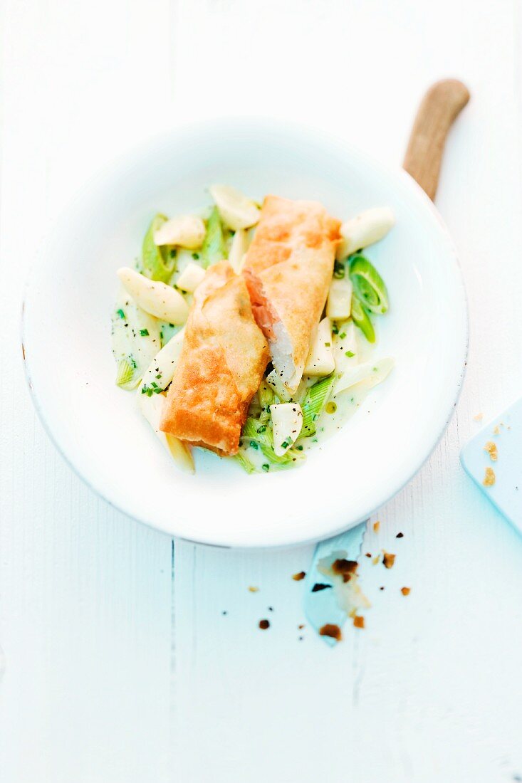 Spring rolls filled with fine fish on a black salsify and leek ragout