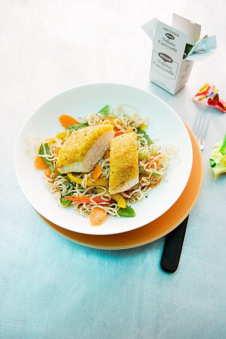 Chicken breast fillet with a curry crust and oriental noodles