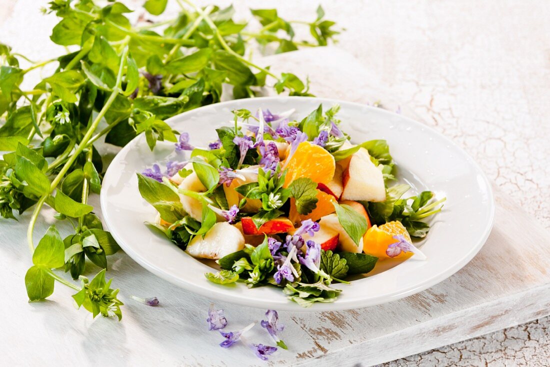 Fruit salad with chickweed and edible flowers