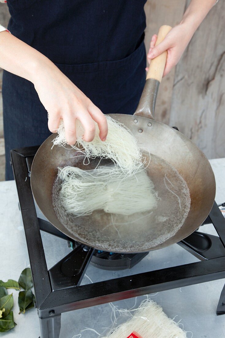 Glass noodles being cooked in a wok