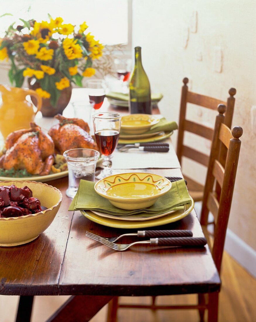 Gedeckter Tisch mit Hähnchen, Salat und Wein