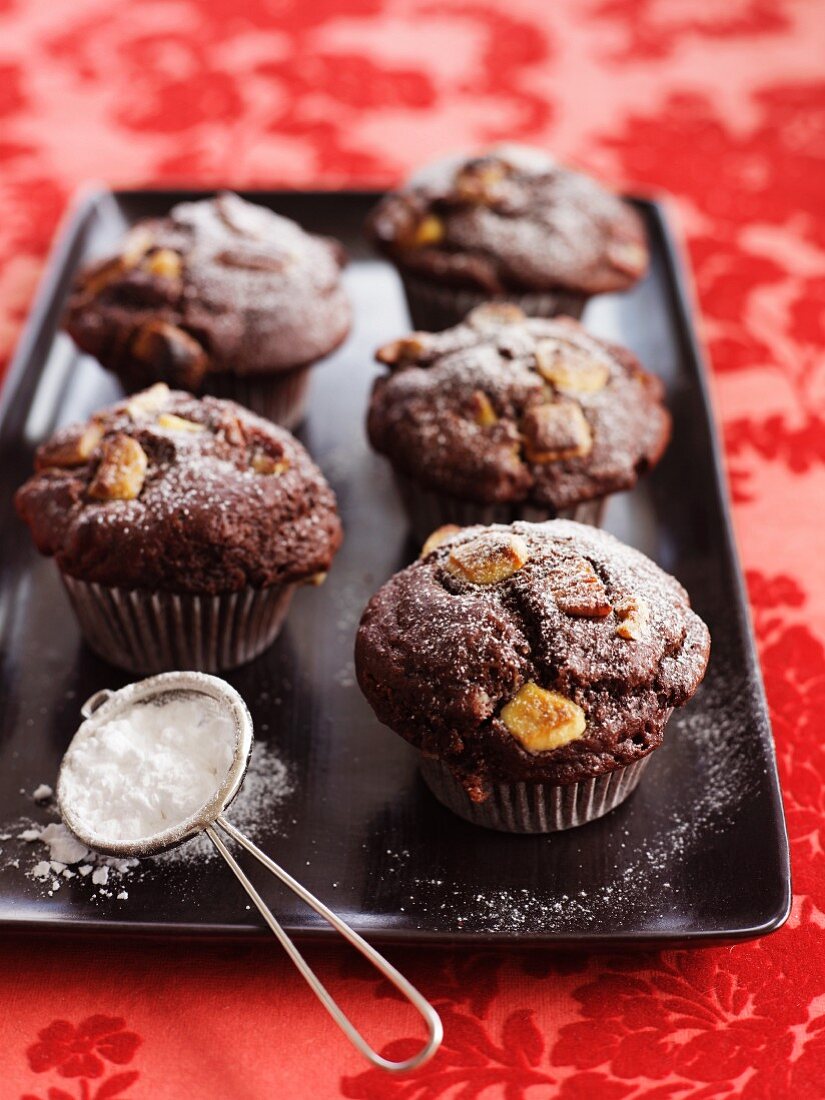 Chocolate muffins with pecan nuts and icing sugar