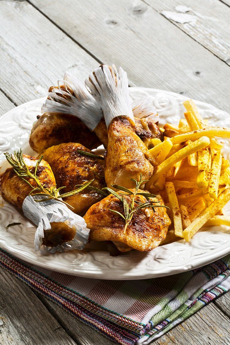 A plate of chicken drumsticks and fries