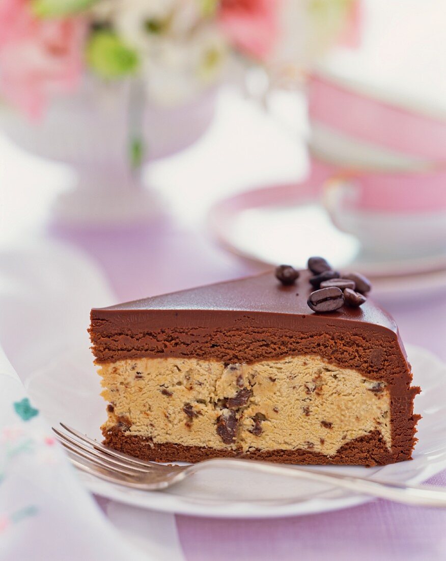 A slice of chocolate cake with mocha beans