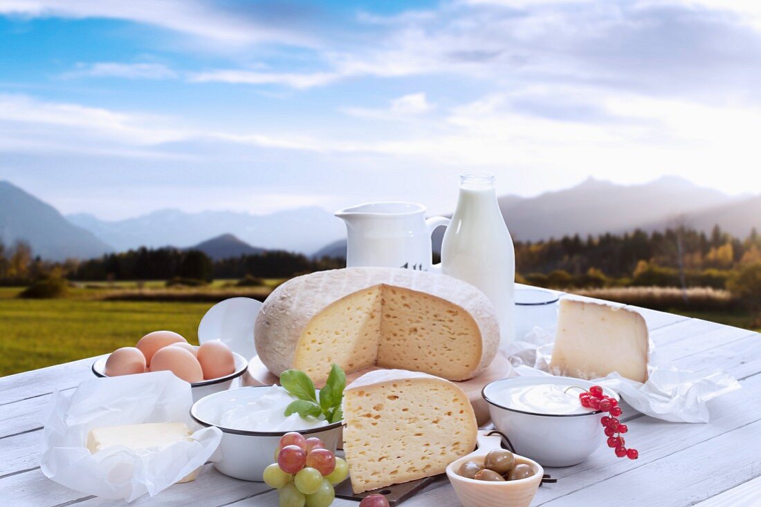 An arrangement of dairy products and eggs against a beautiful mountain skyline