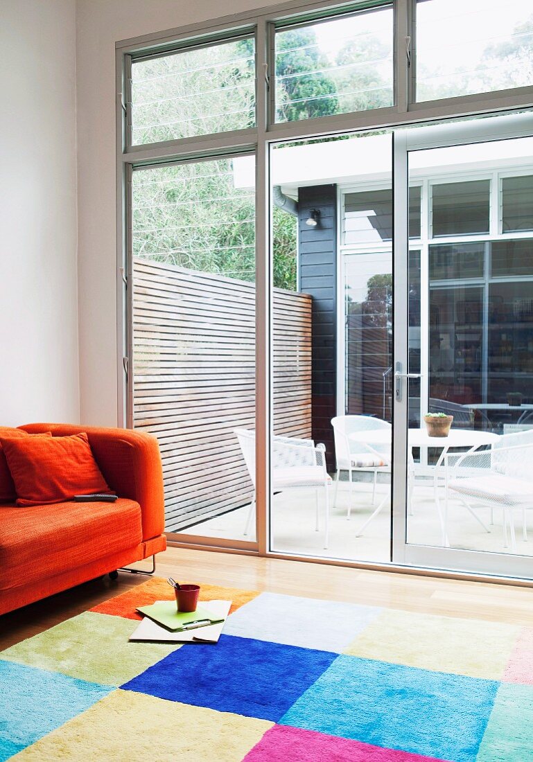 View from colourful lounge area into sunny courtyard of Australian beach house