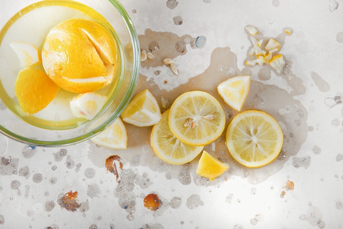 Zitronen in Salzlake in Glasschüssel und auf Steinuntergrund