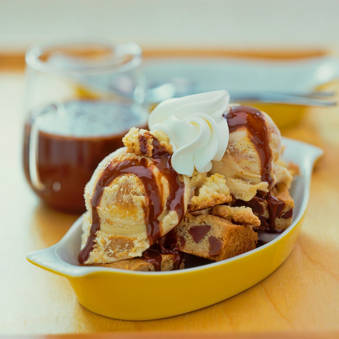 Eiscreme mit Kuchen, Sahne und Karamellsauce