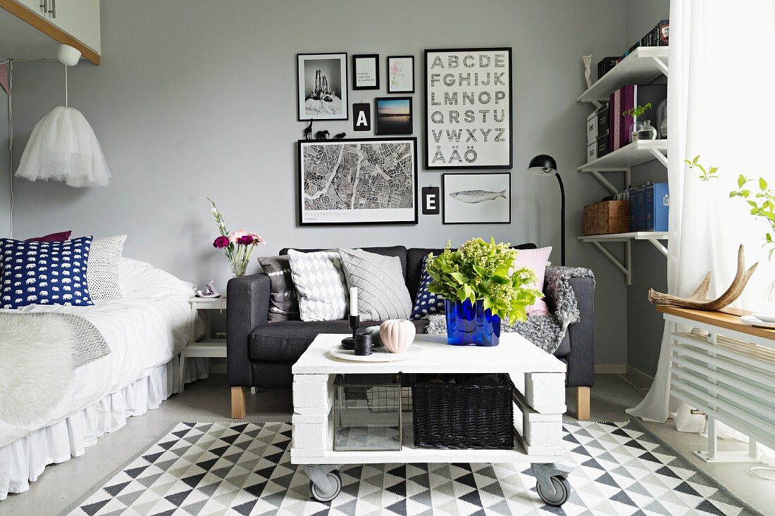 Subtle, grey and white interior with a few colourful accents; Swedish, compact student apartment with bed and seating area