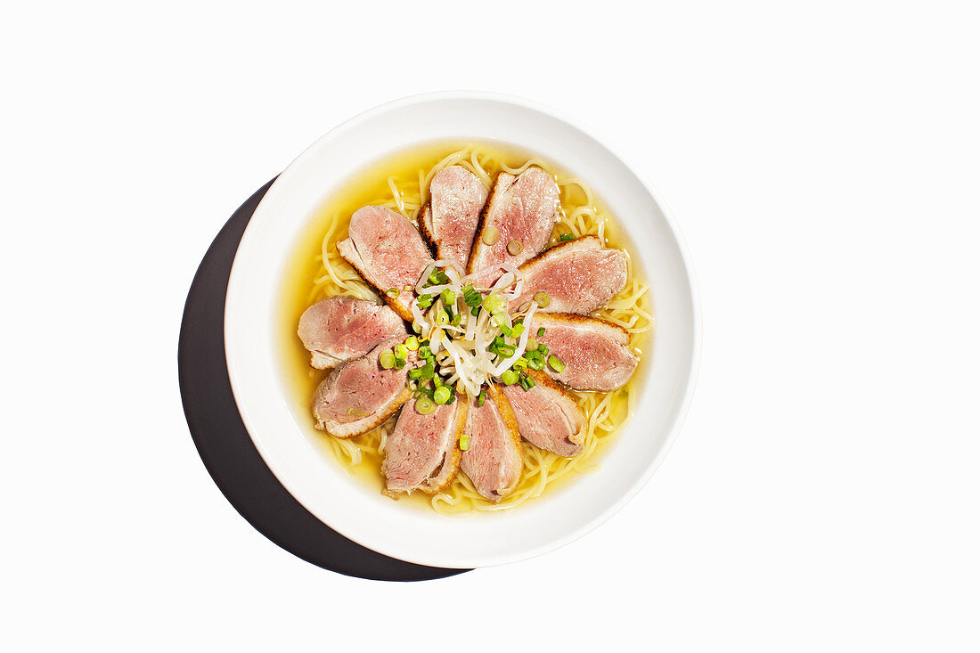 Shio ramen noodle soup with steamed duck, bean sprouts and spring onions (Japan)