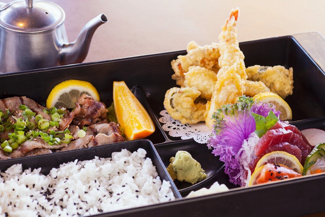 Bentobox mit Amiyaki Rindfleisch, Shrimps- und Gemüsetempura, Sashimi und Reis (Japan)