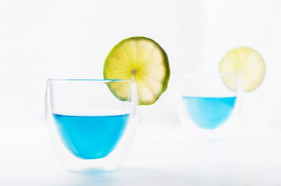 Two glasses of Blue Curacao garnished with lime