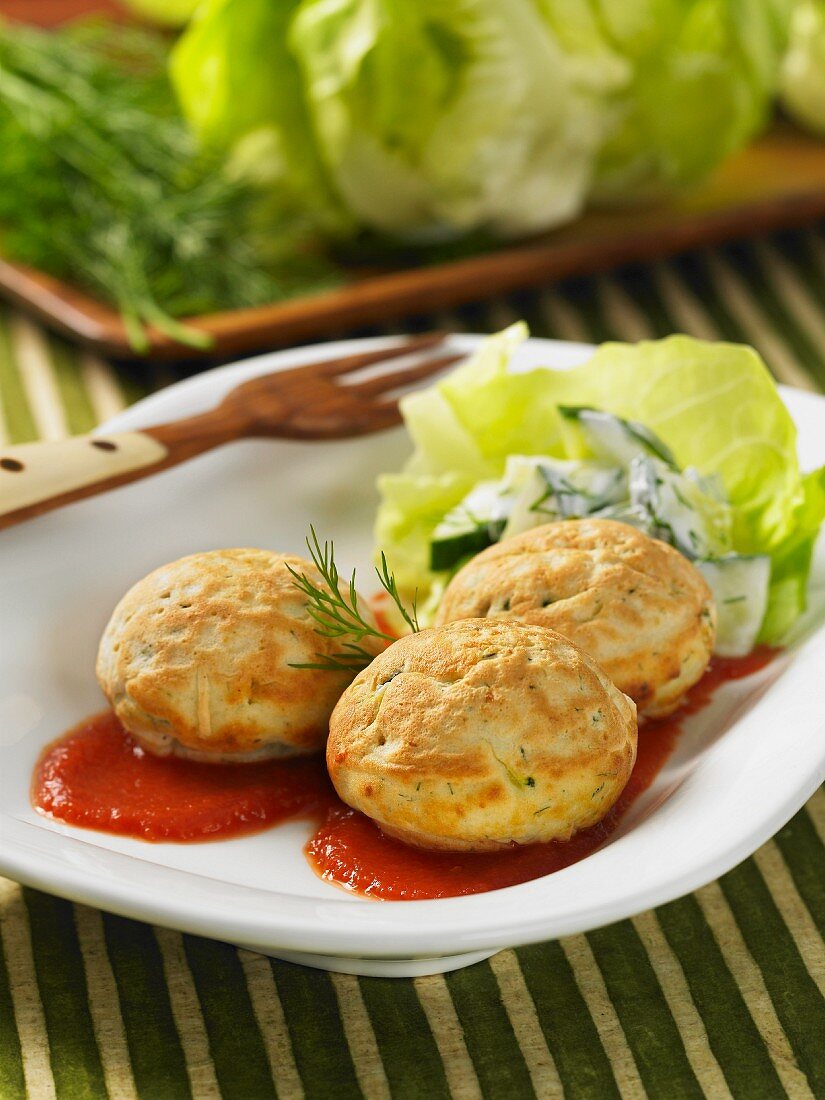 Vegetables cakes with courgette and dill on tomato sauce
