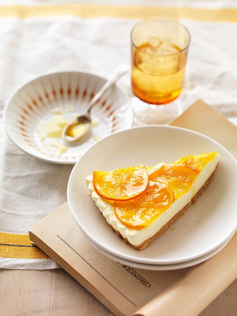 A slice of cream cheese cheesecake with oranges