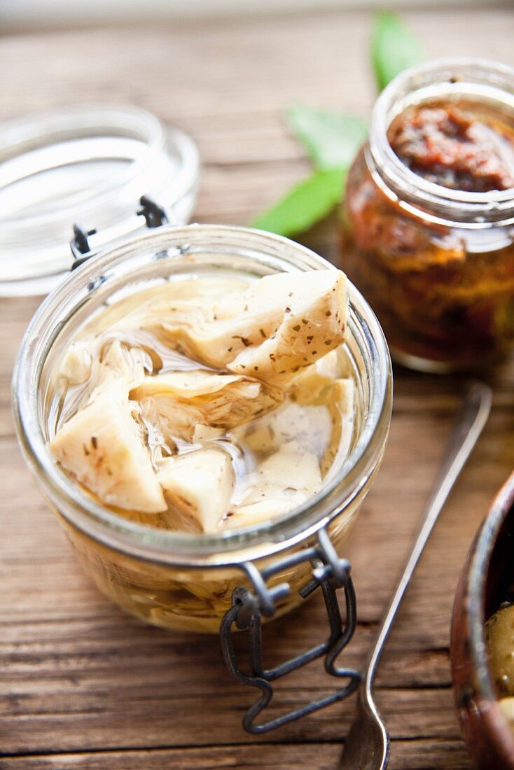 Preserved artichoke hearts and dried tomatoes in jars