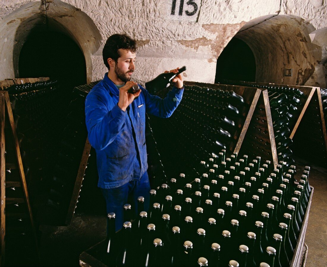 Mann rüttelt Champagnerflaschen der Marke Veuve Clicquot Ponsardin