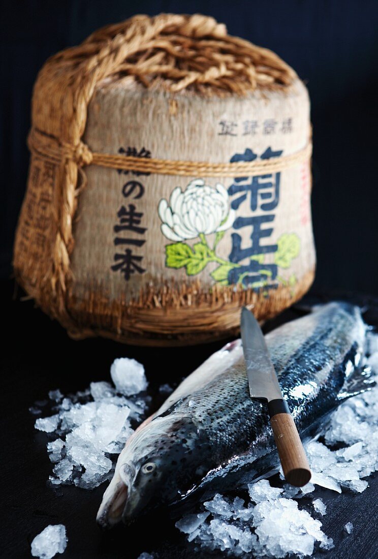 A Japanese baskets decorated with Japanese characters and a trout on ice