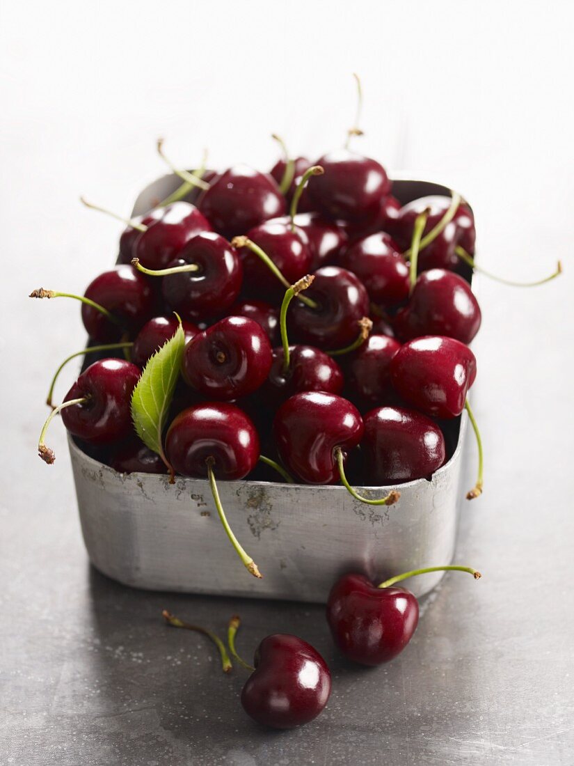 Freshly washed cherries in a metal container