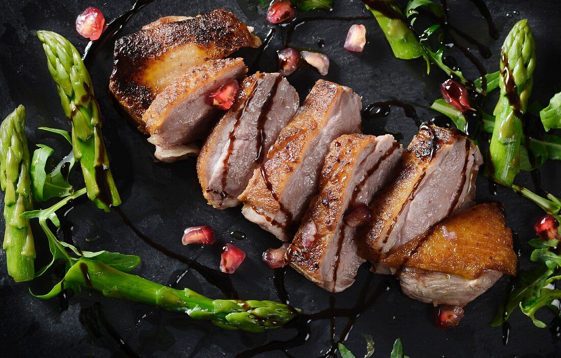 Roast duck with pomegranate seeds and asparagus