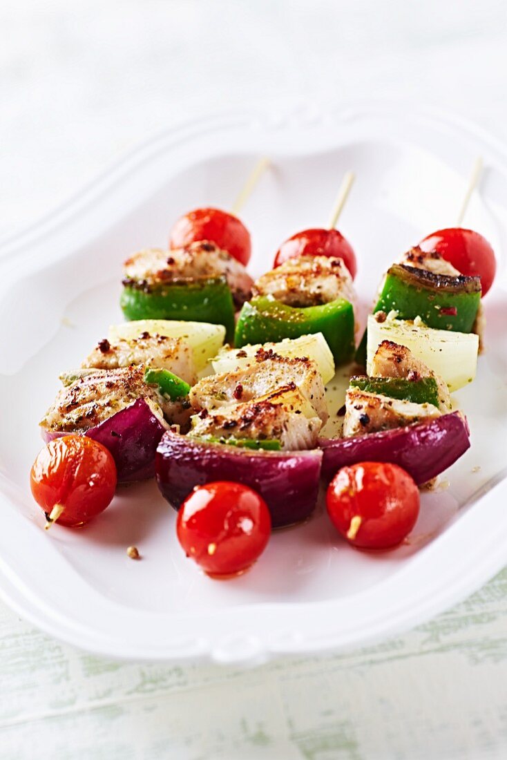 A plate of chicken and vegetable skewers