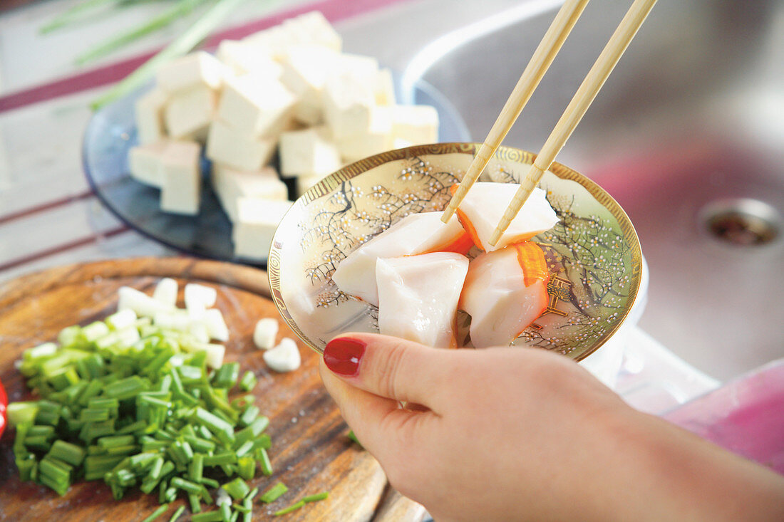 A woman preparing an oriental dish in a kitchen