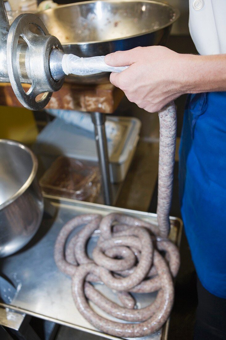 A man making sausages in a commercial kitchen