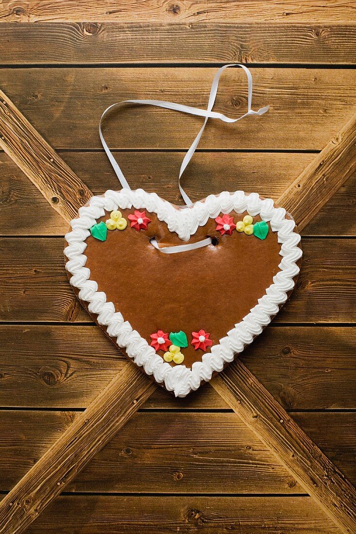 A gingerbread heart hanging on a wooden wall