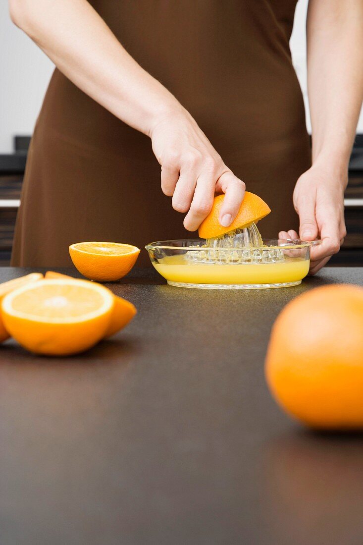 Frau presst Orangen aus