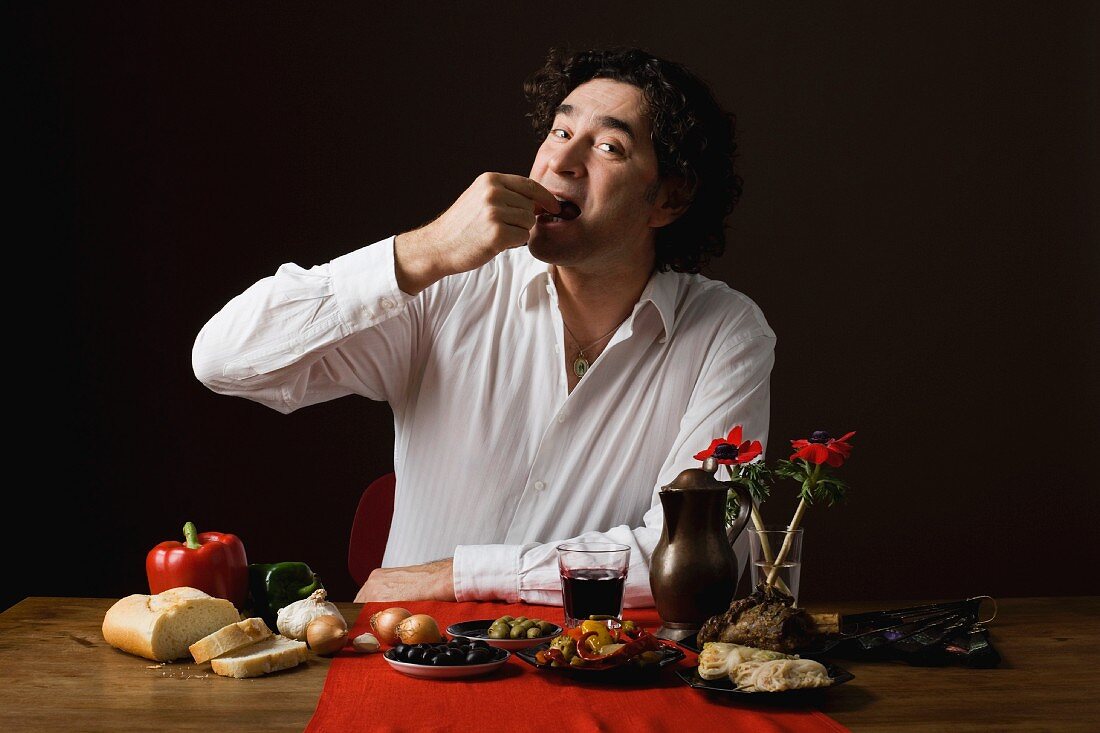 A sterotypical Spanish man eating tapas