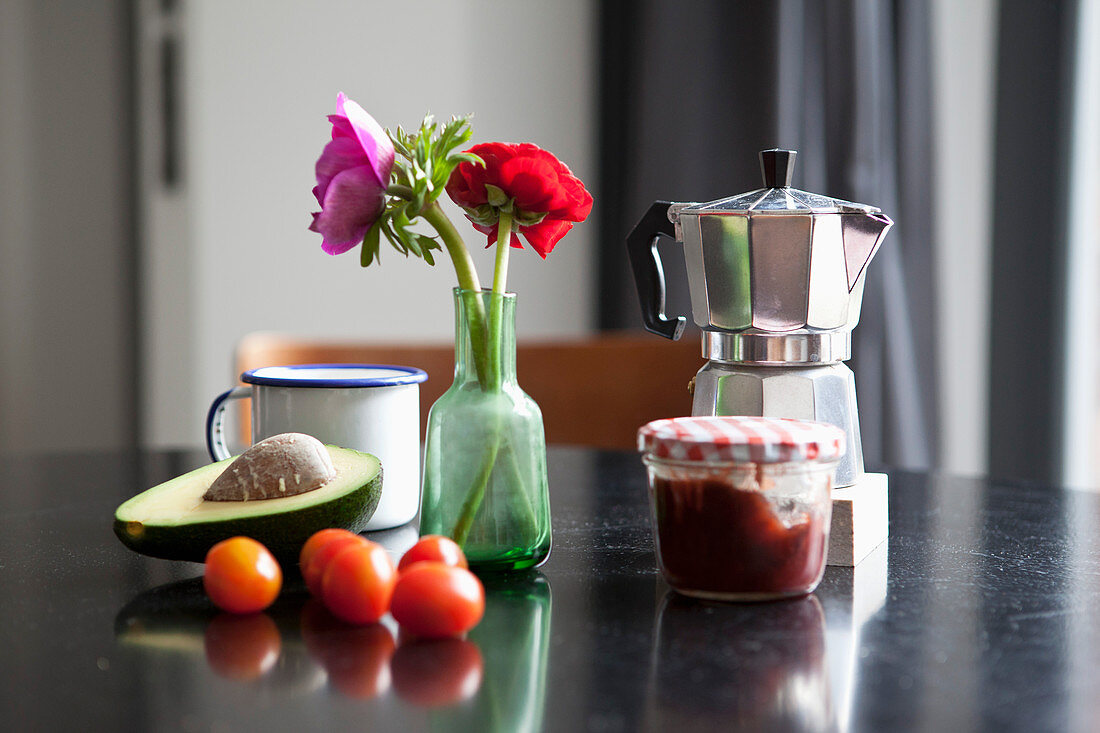 Espressokanne, Kaffeetasse und Frühstücks-Zutaten auf dem Esstisch