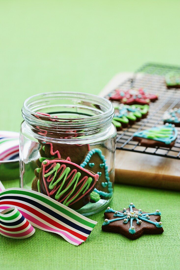 Decorated Christmas biscuits in a jar and on a wire rack