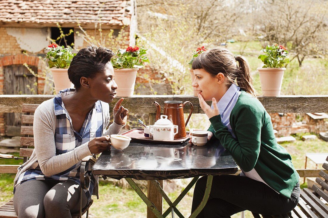 Zwei Frauen beim Kaffeeklatsch im Garten