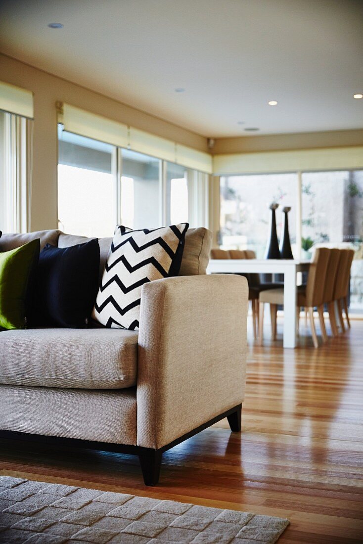 Bright, modern living-dining room with wooden floor and rug