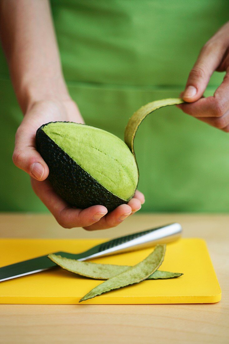 A avocado being peeled