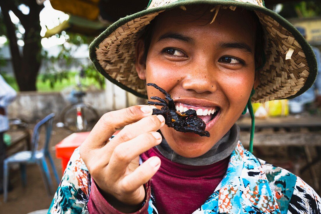 A woman eating fried a tarantula, Cambodia