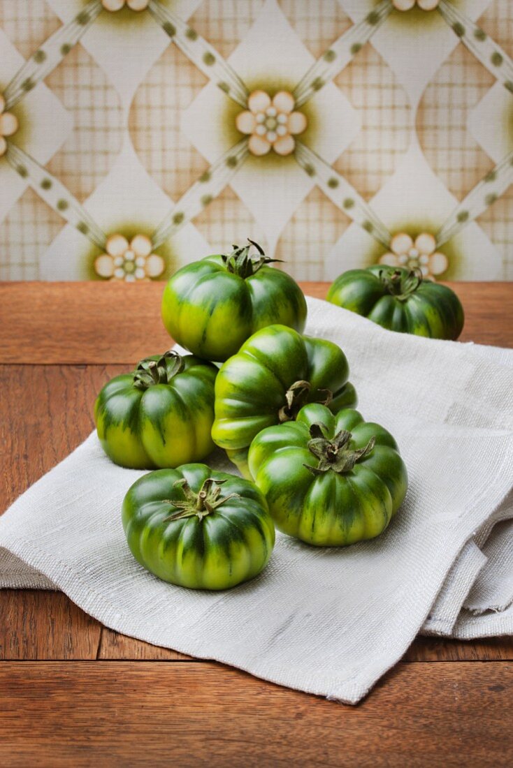 Green tomatoes against retro wallpaper