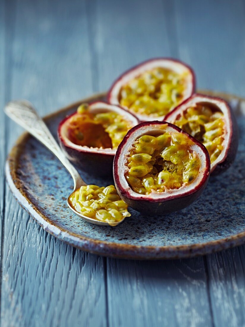 Halved passion fruits on a ceramic plate