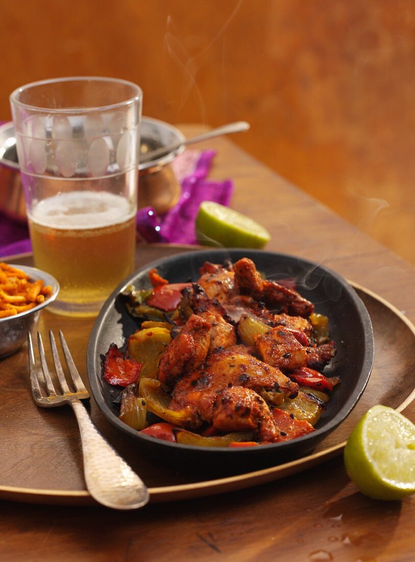 Indian Chicken Sizzler (marinated chicken with onions, peppers and lime, India)