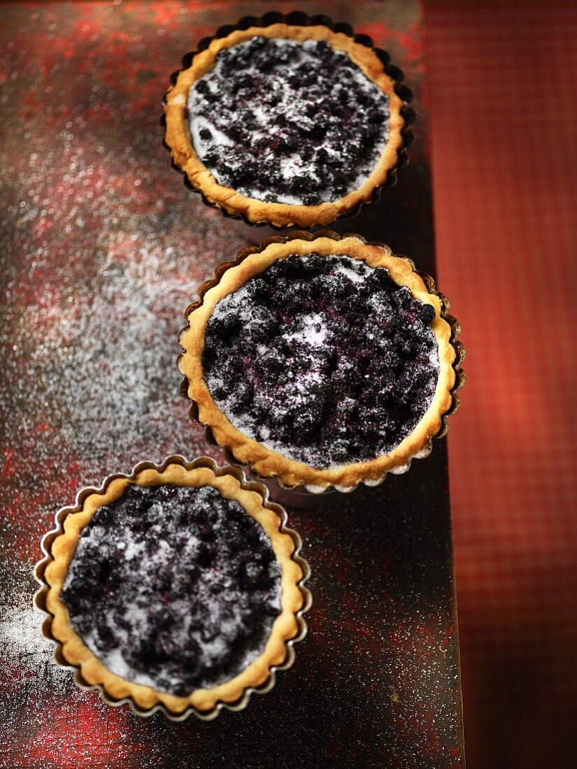 Three blueberry tartlets with sugar