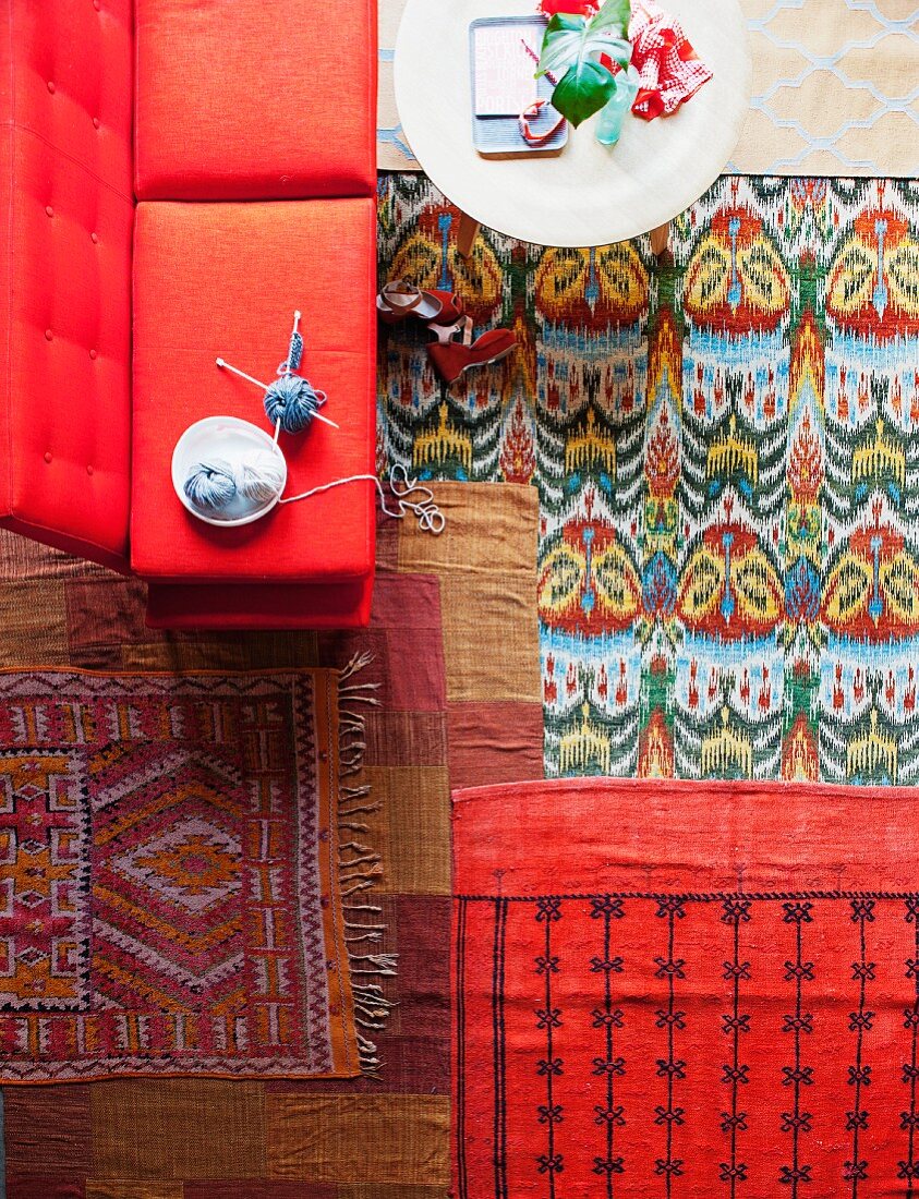 Colourful rugs in living room with coffee table and red sofa
