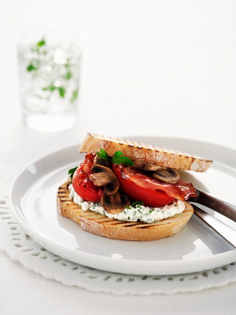 Crispy white bread with cream cheese, tomatoes and mushrooms