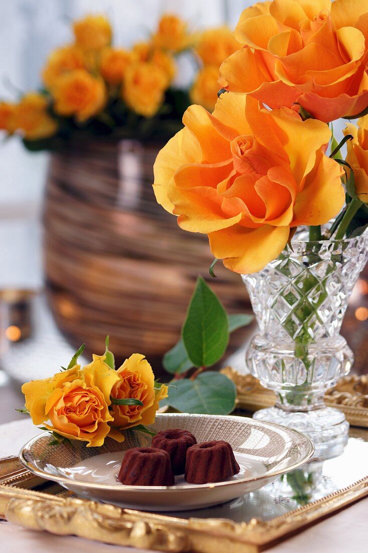Schokopralinen und orangefarbene Rosen