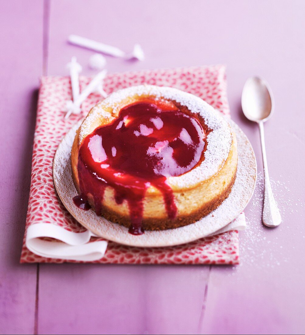 Ricotta cake with raspberry sauce and icing sugar
