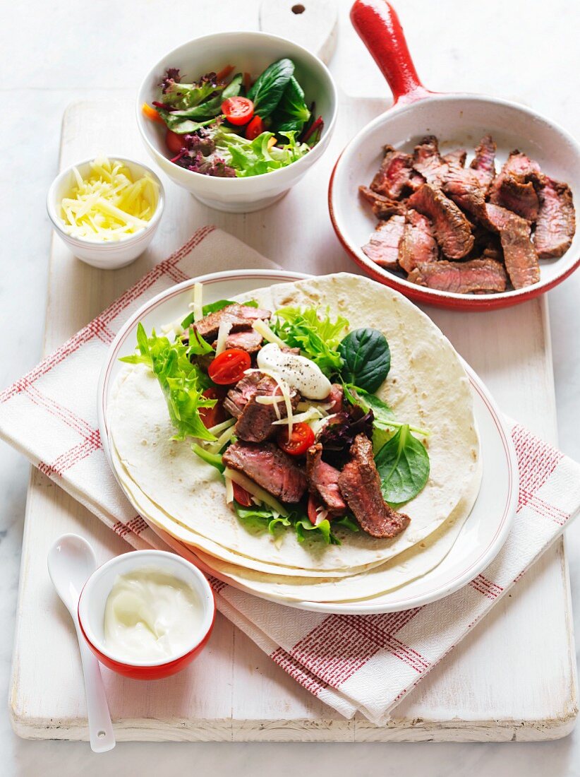 Fajitas with beef, cheese, sour cream and salad
