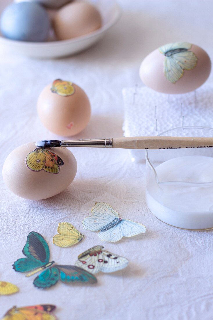 Decorating eggs - applying decoupage butterfly motif using glue